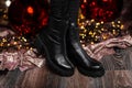 Christmas sale footwear. Winter collection of women`s warm leather shoes. Closeup of female legs in black trendy boots near Royalty Free Stock Photo