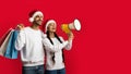 Christmas Sale. Happy Arab Couple In Santa Hats Making Announcement With Megaphone Royalty Free Stock Photo