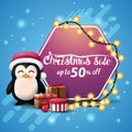 Christmas sale, up to 50% off, square blue banner with pink hexagonal sign wrapped garland, penguin in Santa Claus hat.