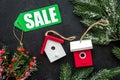 Christmas sale. Word sale on green label near xmas toys and spruce branch on black background top view Royalty Free Stock Photo