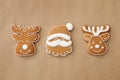 Christmas Santa Claus face and deer shaped gingerbread cookies on brown background, flat lay Royalty Free Stock Photo