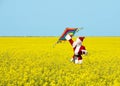 Christmas Santa Claus fling a kite in blooming yellow field.