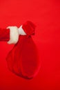 Christmas. Santa Claus hand holding red sack full of presents over Royalty Free Stock Photo