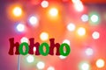 Christmas Santa Claus `hohoho` exclamation photo booth props with colorful tree lights bokeh background.