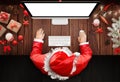 Christmas in Santa Claus home. Santa Claus use a computer to respond to letters