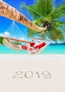 Christmas Santa Claus relax in hammock under palm at tropical sandy beach, season of happy new year 2019 Royalty Free Stock Photo