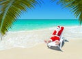 Christmas Santa Claus relax in sunlounger at tropical sandy palm beach