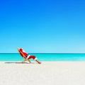 Christmas Santa Claus relaxing in sunlounger at ocean tropical b