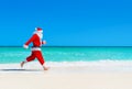 Christmas Santa Claus run at tropical beach against waves splash Royalty Free Stock Photo