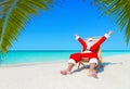 Christmas Santa Claus on sunlounger happy with palm sandy beach holidays Royalty Free Stock Photo