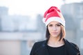 Christmas Santa hat outdoors woman smiling portrait . Smiling happy girl wearing her Santa hat with city urban background Royalty Free Stock Photo