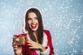 Christmas Santa hat woman portrait hold christmas gift boxs. Smiling happy girl on blue background. Portrait of beautiful girl Royalty Free Stock Photo