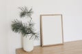 Christmas Scandinavian interior. Minimal winter artistic composition. Blank vertical wooden picture frame mockup. Pine