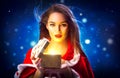 Christmas. Beauty brunette young woman in party costume opening gift box over holiday night background Royalty Free Stock Photo