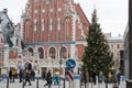 Christmas scene. Christmas tree on the square on the background of a beautiful building. People walking by. Riga. Latvia. Royalty Free Stock Photo