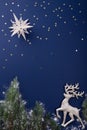 Christmas scene with reindeer on dark blue background.