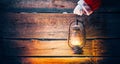 Christmas scene. Santa Claus hand holding vintage oil lamp Royalty Free Stock Photo