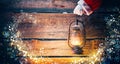 Christmas scene. Santa Claus hand holding vintage oil lamp