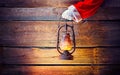 Christmas scene. Santa`s hand holding vintage oil lamp Royalty Free Stock Photo