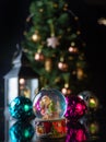 Christmas scene with tree, lights and snow globe. Selective focus on black background Royalty Free Stock Photo