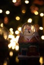 Christmas scene with tree, lights and snow globe. Selective focus on black background Royalty Free Stock Photo