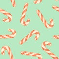 Christmas seamless pattern with candy canes. Red and white striped candy canes on a blue background Royalty Free Stock Photo