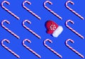 Christmas seamless pattern. Candy canes and Santa`s red mitten on blue background. Royalty Free Stock Photo