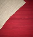 Christmas Season Background that is red shiplap wood boards with off white burlap in a corner.  It`s vertical with an above view Royalty Free Stock Photo