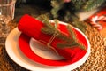 christmas set table, glass goblet and plates with red napkin and branch. Royalty Free Stock Photo