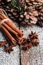Christmas setting with bundle of cinnamon, anise stars and other christmas decorations on the rustic wooden background Royalty Free Stock Photo