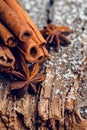 Christmas setting with bundle of cinnamon, anise stars and other christmas decorations on the rustic wooden background Royalty Free Stock Photo