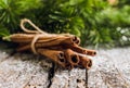 Christmas setting with bundle of cinnamon and pine branches on the rustic wooden background Royalty Free Stock Photo