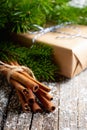 Christmas setting with bundle of cinnamon and pine branches on the rustic wooden background Royalty Free Stock Photo