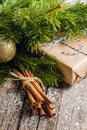 Christmas setting with bundle of cinnamon and pine branches on the rustic wooden background Royalty Free Stock Photo