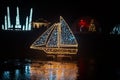 Christmas ship made of shining garlands in the dark.Christmas installations from garlands.Shimmering street scenery