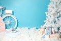 Christmas shooting location with white christmas tree decorated with toys, present boxes, snow and bike. Artificial fir