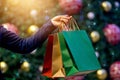 Christmas shopping bags in hand on christmas decoration h Royalty Free Stock Photo