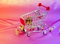 Christmas shopping cart with gift, holiday decorations on pink pastel background top view. Flat lay style. Christmas Royalty Free Stock Photo