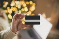 Christmas shopping online and black friday sales. Hand holding credit card on background of laptop with blank screen and christmas Royalty Free Stock Photo