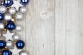 Christmas side border of blue and silver ornaments on gray wood Royalty Free Stock Photo
