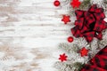 Christmas side border of ornaments, snowy branches and red and black check plaid bow and ribbon on a white wood background Royalty Free Stock Photo