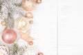 Christmas side border of snowy branches and dusty rose, gold, and white ornaments. over a white wood background Royalty Free Stock Photo