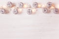 Christmas silver apples decoration and lights burning on a white wooden background. Royalty Free Stock Photo