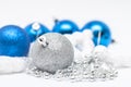 Christmas silver  ball in  focus and blue balls in background with ribbons and snow Royalty Free Stock Photo