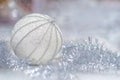 Christmas silver ball and tinsel decoration on a light blurry background with copy space. Royalty Free Stock Photo