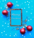 Christmas silver mockup frame and red baubles on bright blue background. Royalty Free Stock Photo