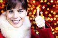 christmas smiling woman like hand with thumb up on blurred brigh