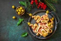 Christmas snack Christmas tree with olive and bacon and christmas decor on a slate tabletop.