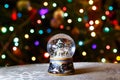 Christmas Snow Globe in front of Christmas tree lights closeup