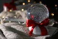 Christmas snow globe with knitting clothes on blurred background. Royalty Free Stock Photo